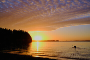Sunset paddle.  Lone kayaker heads out to enjoy setting sun