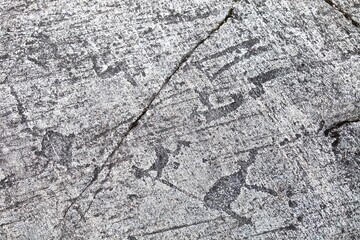 Ancient petroglyphs on the surface of granite slabs close-up. Ancient images of people and animals on a stone surface. Rock painting of ancient people. Close-up of paintings and rock carvings. Art.