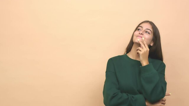 Young caucasian woman looking sideways with doubtful and skeptical expression