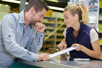 sales assistant dealing with customer over shop counter