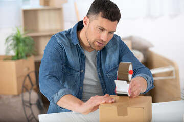 man sealing with tape sitting on the floor