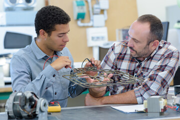 apprentice and man fixing a machine