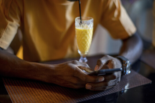 Young African-American male drinking cocktail and having fun at the bar