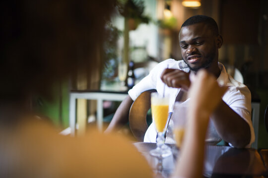 Young African-American male drinking cocktail and having fun at the bar - Powered by Adobe