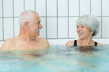 senior couple relaxing at a swimming pool