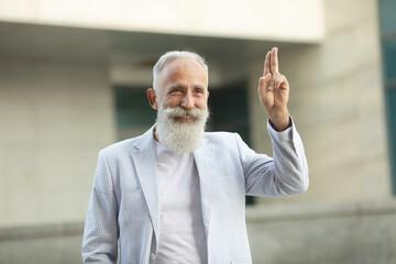 Bearded senior man greeting gesture.