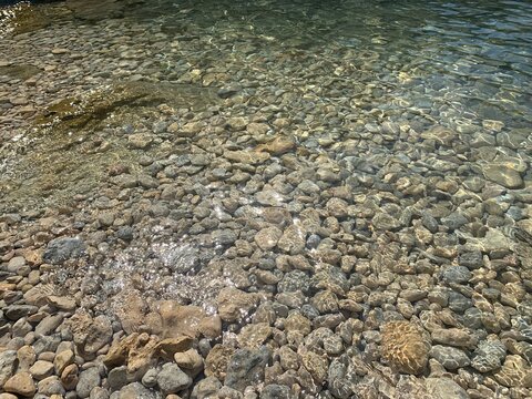 Sea stones on the beach. Crystal clear water. Pebble beach. Tranquility. Calm.