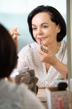 Elegant Elderly Woman Putting On Pink Lipstick