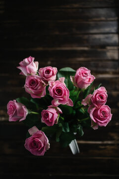 Pink roses on wooden background.