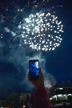 Person taking photos of fireworks using smartphone