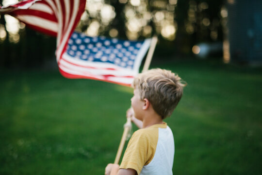 intentionally blurred image of a boy holding an American flag