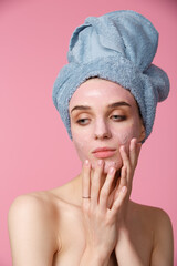 Beauty treatment - woman applying clay face mask