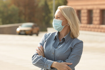 COVID-19 Social Distancing Woman in city street wearing surgical mask against disease virus SARS-CoV-2.