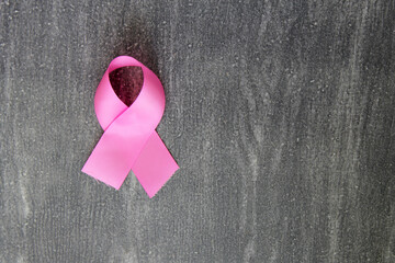 pink ribbon on vintage gray wooden background for campaign against breast cancer