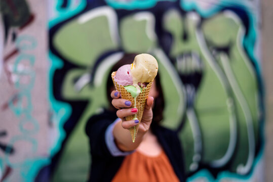 Girl holding ice cream in fron of her face