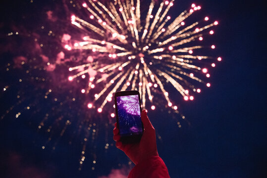 Person taking photos of fireworks using smartphone