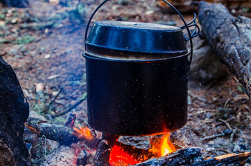 fire burns in the campaign. pot of tea by the fire.