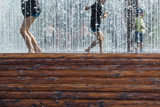Children playing in water fountain in summer