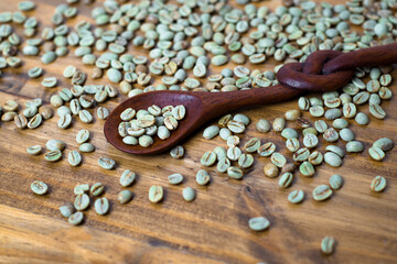 Fototapeta na wymiar green coffee on wooden table with spoon