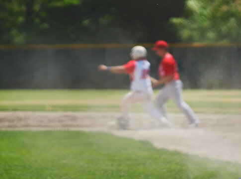 Blurry image of baseball players at second base