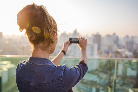 Woman taking a photo of a Bangkok skyline