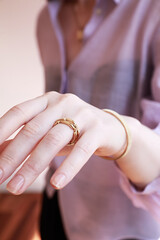 Close-up caucasian woman hand showing trendy wedding ring over wall background. Copy paste text...