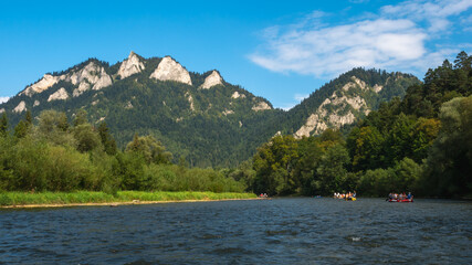 Traditional rafting on the Dunajec Gorge and view of Three Crowns Massif, Pieniny, Poland. © Kamil