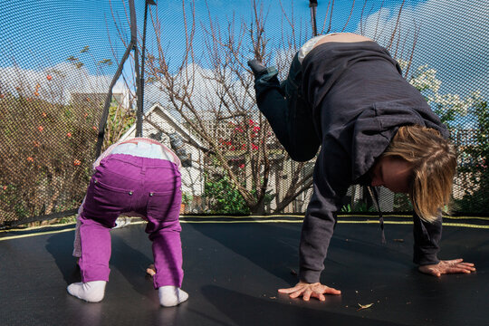 Cute little girl playing on trampoline with her dad