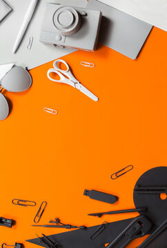 Grey black and white office stuff on orange background