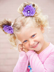 little girl with curly blonde hair on a walk, summer day