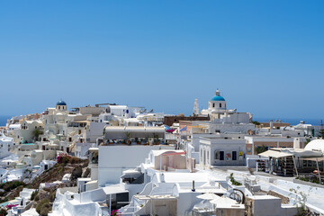 Beautiful view of  Oia, the famous town with its typical white houses on a sunny day.  Santorini island, Cyclades, Greece, Europe.