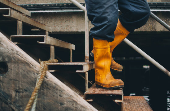 A man in yellow boots walks down steps