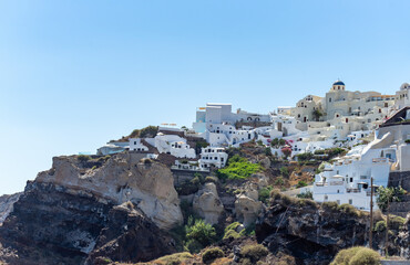 Fototapeta na wymiar Beautiful view of Oia, the famous town with its typical white houses on a sunny day. Santorini island, Cyclades, Greece, Europe.
