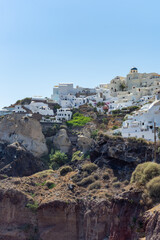 Beautiful view of  Oia, the famous town with its typical white houses on a sunny day.  Santorini island, Cyclades, Greece, Europe.