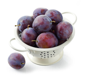 fresh ripe plums in colander