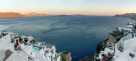 Beautiful panoramic view from Oia to caldera and volcano on a sunny day. Picturesque natural background with copy space for text. Santorini island, Cyclades, Greece, Europe.