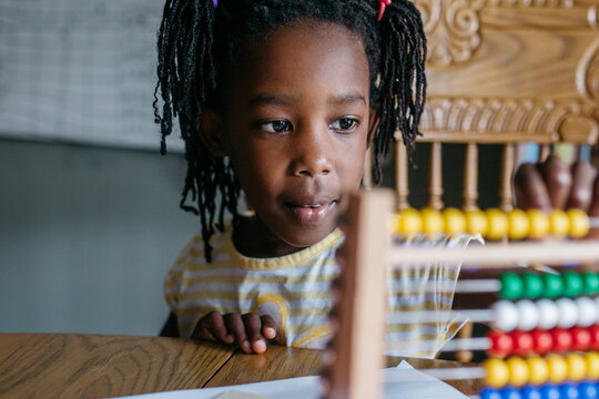African American girl using an abacus in her kindergarten class