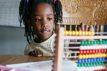 African American girl counting the beads on an abacus