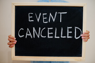 Event cancelled. Coronavirus concept. Boy hold inscription on the board.