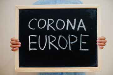 Corona Europe. Coronavirus concept. Boy hold inscription on the board.