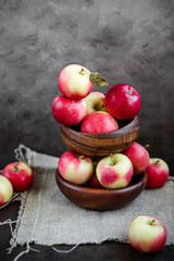 Lots of small apples in wooden bowls. Autumn harvest of fruits on a dark background.