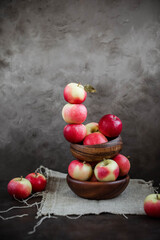 Lots of small apples in wooden bowls. Autumn harvest of fruits on a dark background.