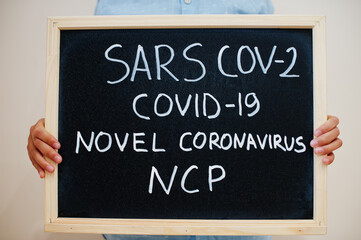 Sars Cov-2 Covid-19 novel NCP. Coronavirus concept. Boy hold inscription on the board.