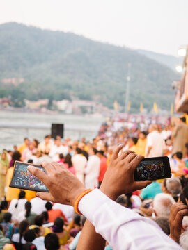 Hands crossed with smartphones taking photo of people at india ceremony