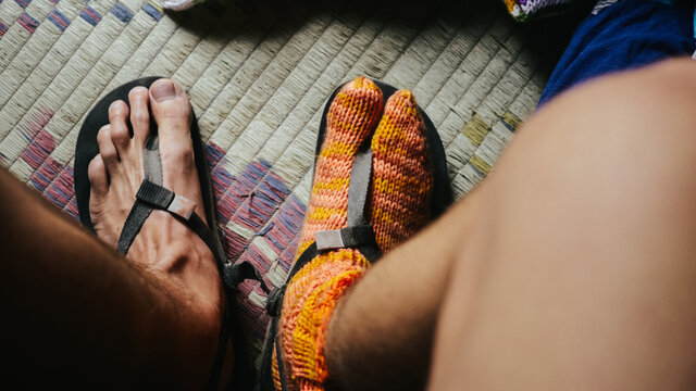 Man wearing socks in minimalistic sandals