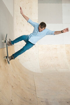 Guy doing a stunt in skatepark