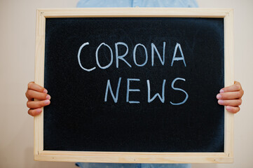 Corona news. Coronavirus concept. Boy hold inscription on the board.