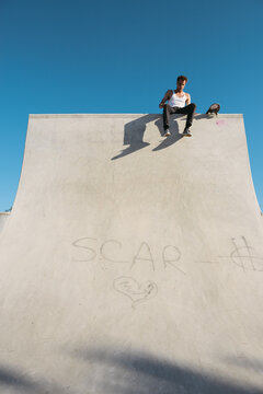 Smoking skater resting on halfpipe