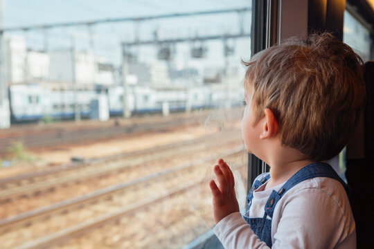 Little boy looking out the window in a moving train