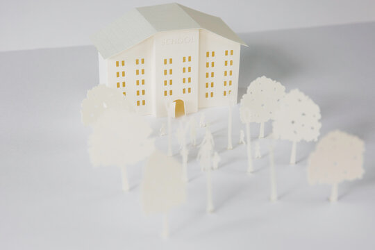 School building cut out of paper with its surroundings